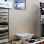 Showroom display section featuring an EDGING rack, Caesarstone countertop sample towers, and stone edge profile samples.