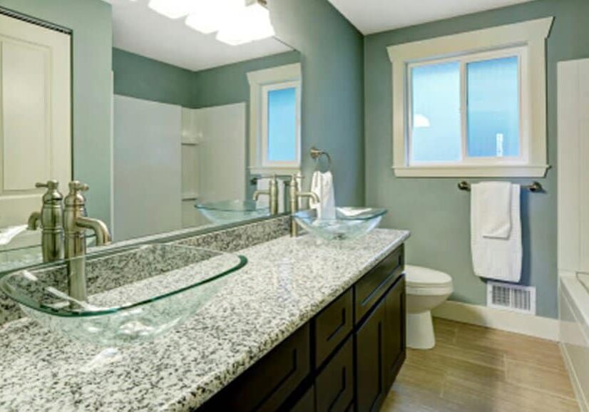 Modern bathroom featuring sage green walls, dark wood double vanity, granite countertop with dual glass vessel sinks, and a shower-tub combo.